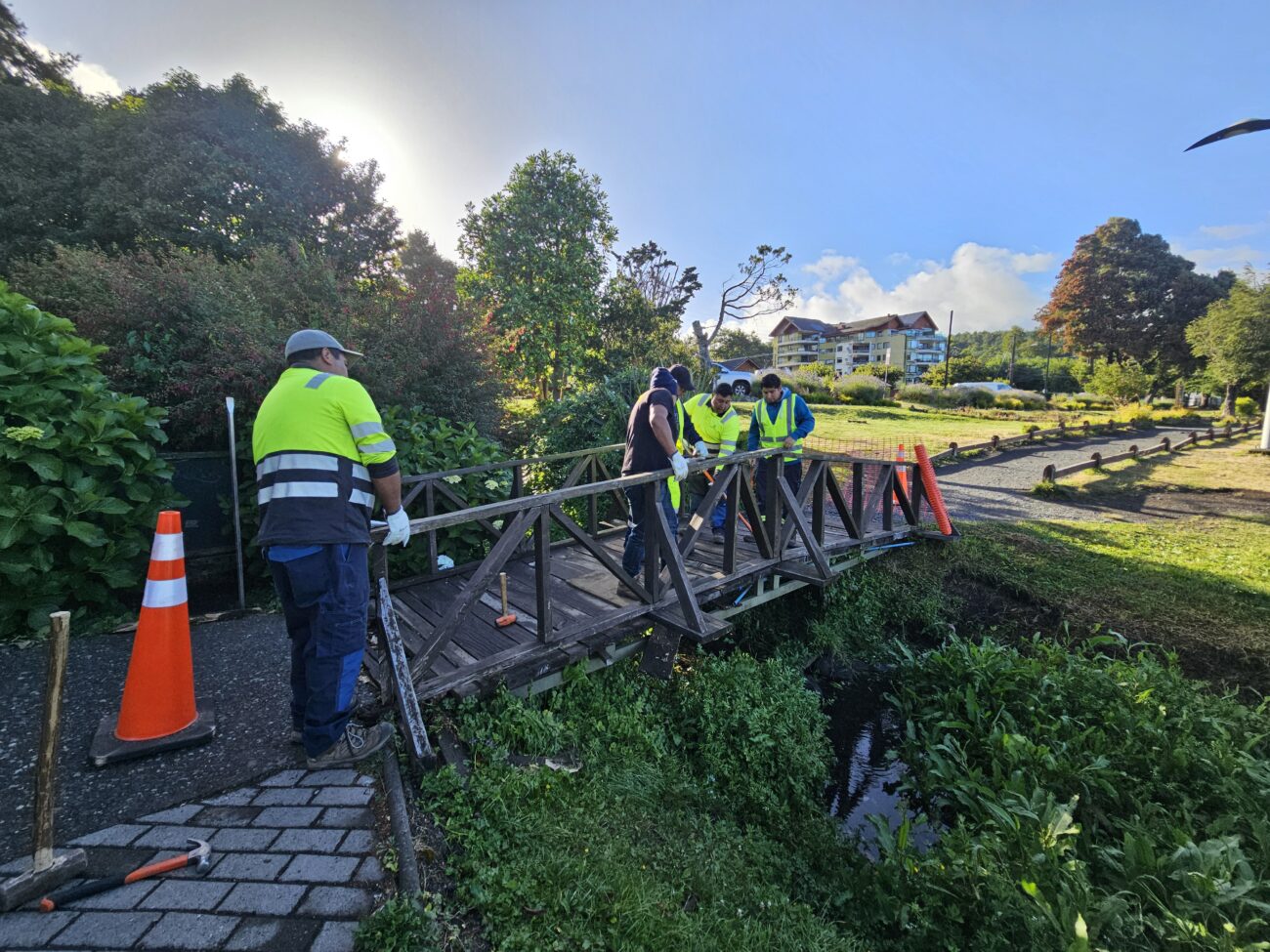 FUNCIONARIOS MUNICIPALES DE PUCÓN REPARAN PUENTE EN LA POZA